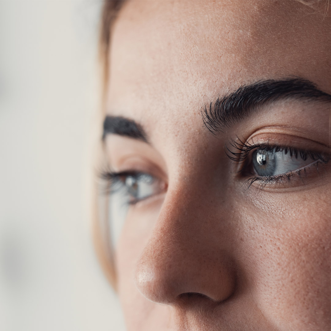 Närbild av kvinna som tittar snett åt vänster.