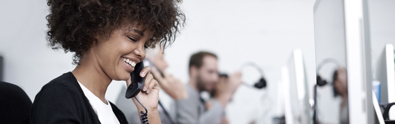 En kvinna på ett call center svarar på frågor över telefon